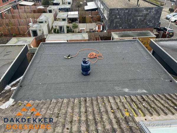 Plat dak met nieuwe bitumen dakbedekking en brandgereedschap in Doesburg
