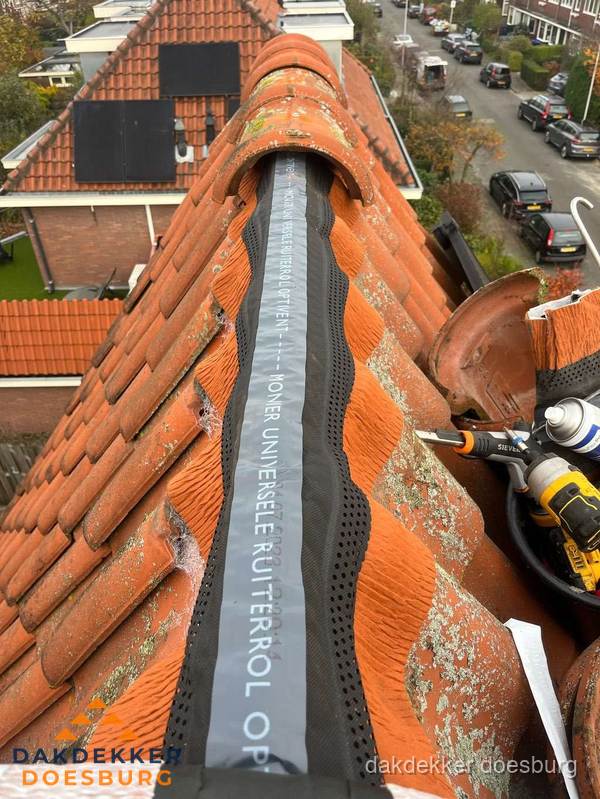 Dakdekker vervangt nokvorst met ruiterrol op pannendak in Doesburg