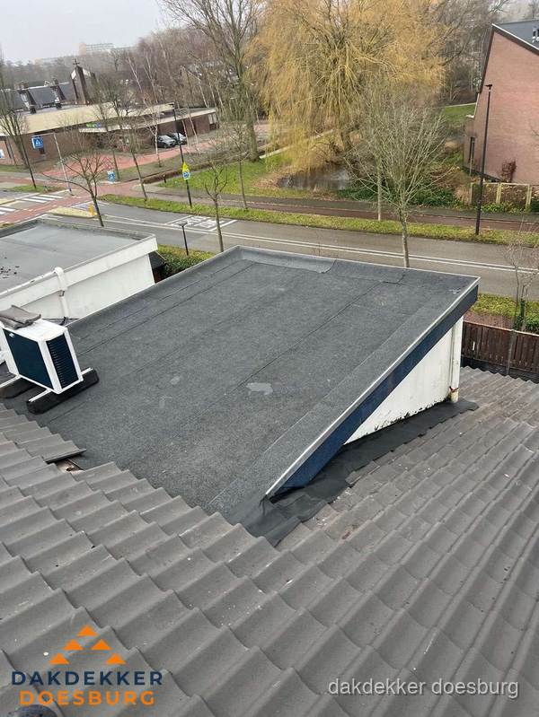 Plat dak met bitumen dakbedekking naast schuin pannendak in Doesburg
