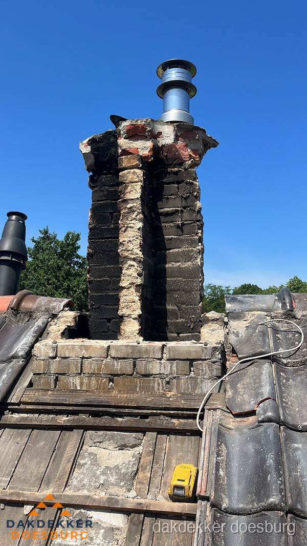 Beschadigde schoorsteen met nieuwe rookgasafvoer op oud dak in Doesburg