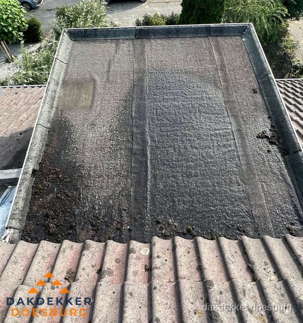 Verouderd plat dak met bitumen en slijtage voor lekkage inspectie in Doesburg