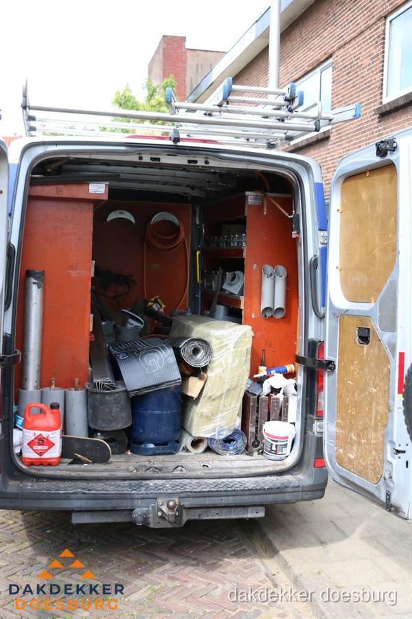 Bedrijfsbus van dakdekker met gereedschap en materialen in Doesburg