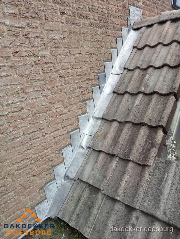 Loodslabben langs dakaansluiting bij bakstenen muur in Doesburg