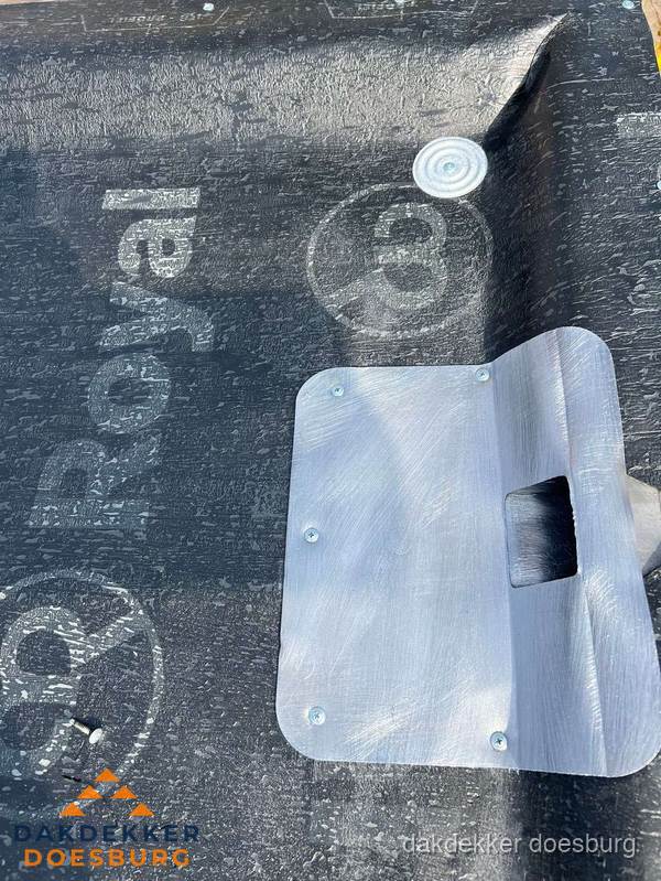 Dakdoorvoer met metalen afvoerplaat op bitumen dak in Doesburg