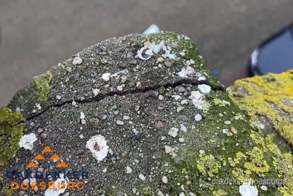 Beschadigde en verweerde nokvorst met scheuren en mos in Doesburg