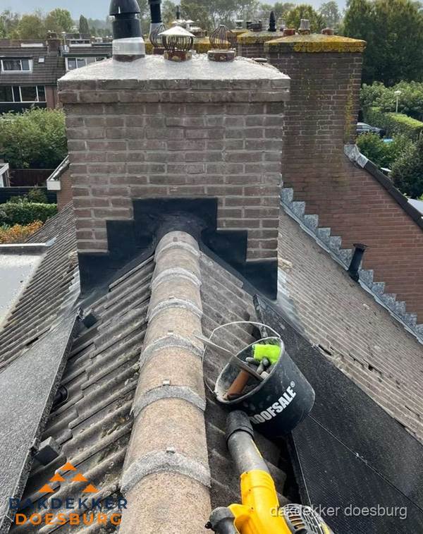 Schoorsteen met loodaansluiting en nokvorst op pannendak in Doesburg