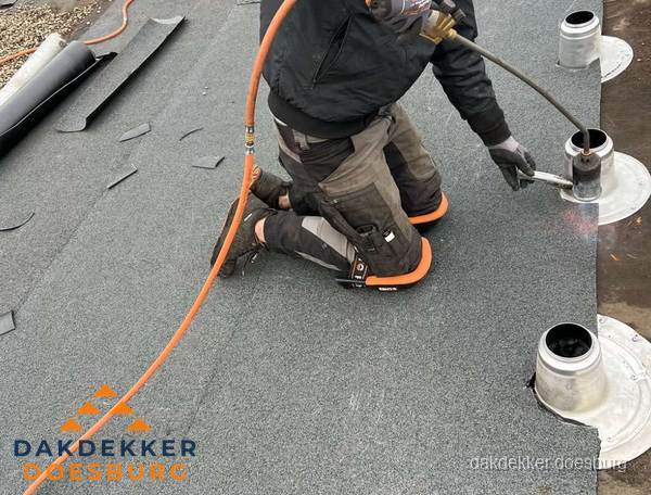 Dakdekker repareert bitumen dakleer bij dakdoorvoer in Doesburg