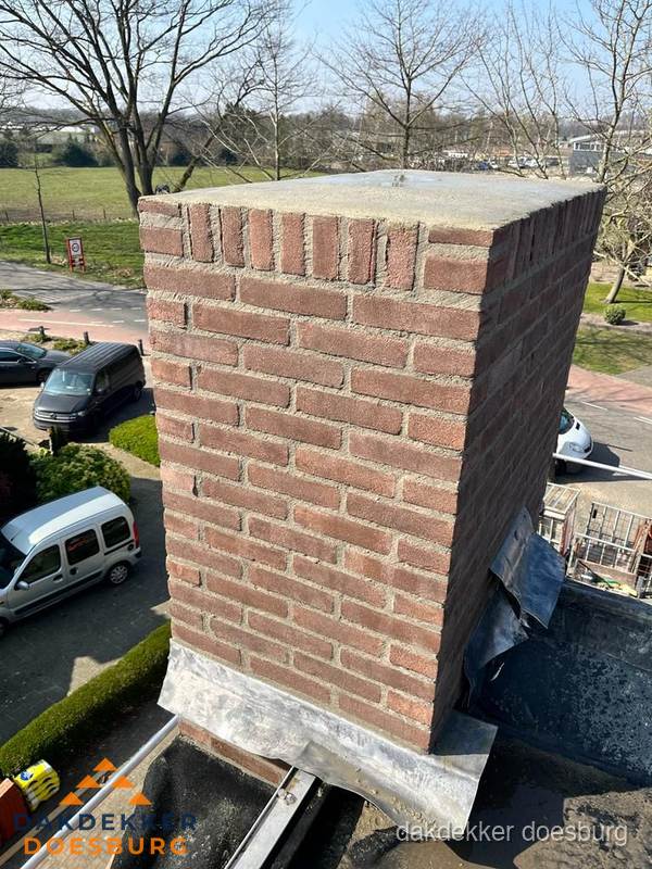 Gemetselde schoorsteen met loodaansluiting op dak in Doesburg
