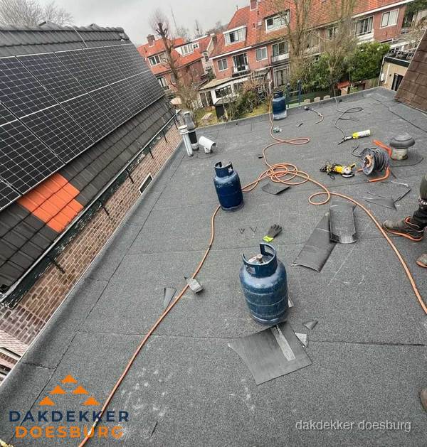 Daklekkage repareren met brandgereedschap op plat dak in Doesburg