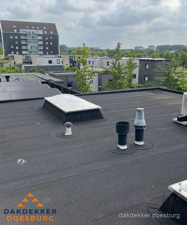 Groot plat dak met lichtkoepel en dakdoorvoeren in Doesburg