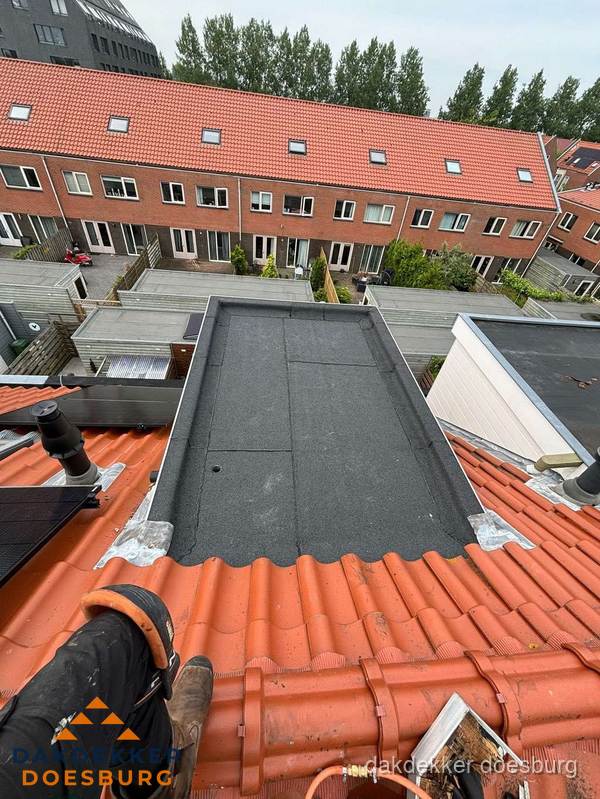Bitumen dak reparatie op plat dak tussen dakpannen in Doesburg